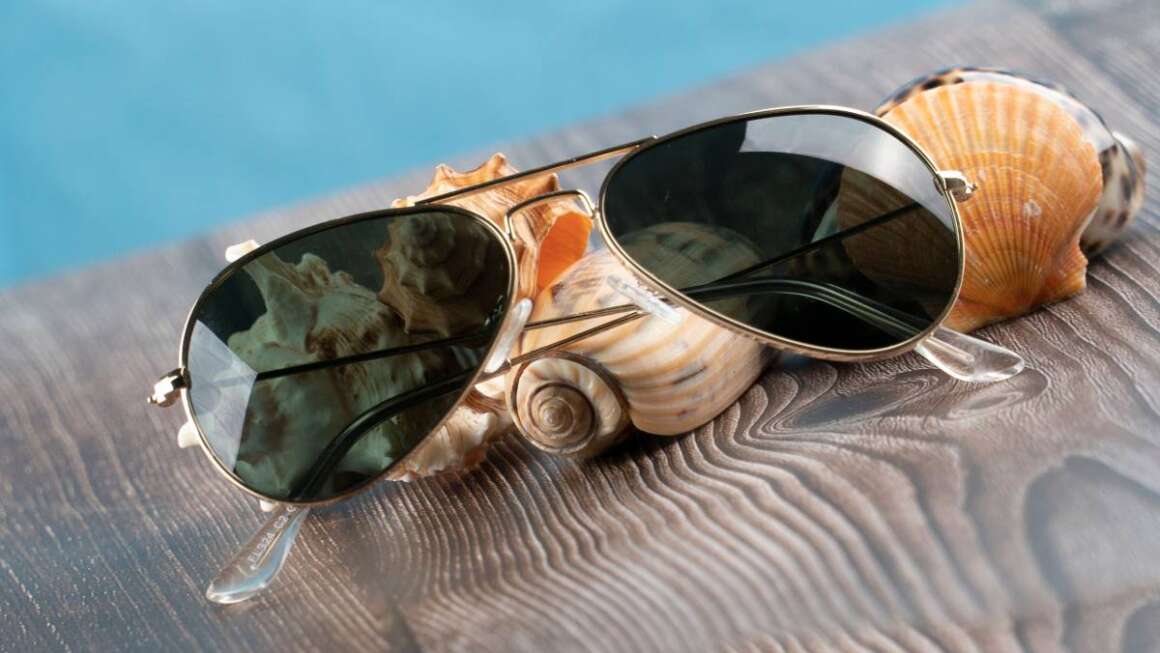A closeup shot of sunglasses on sea shells in a marine environment
